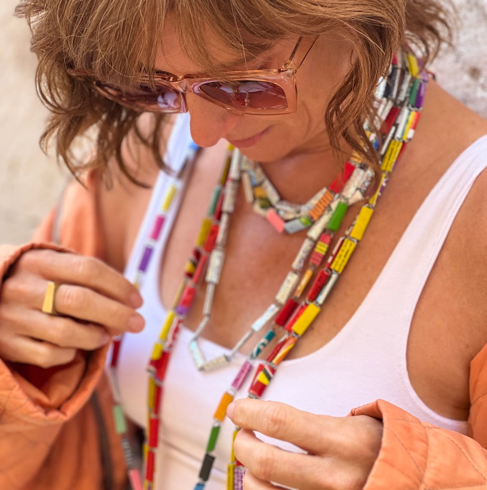 Colorful candy wrapper necklaces on a woman in a white tank and orange button down - madera design studio