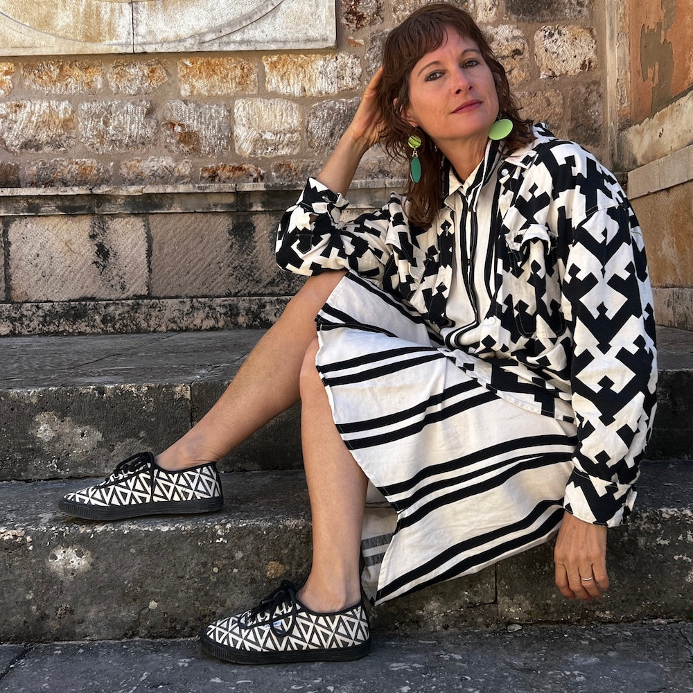 Stacey shevlin designer of Mad Era Design Studio in mixed black and white patterns sitting on steps