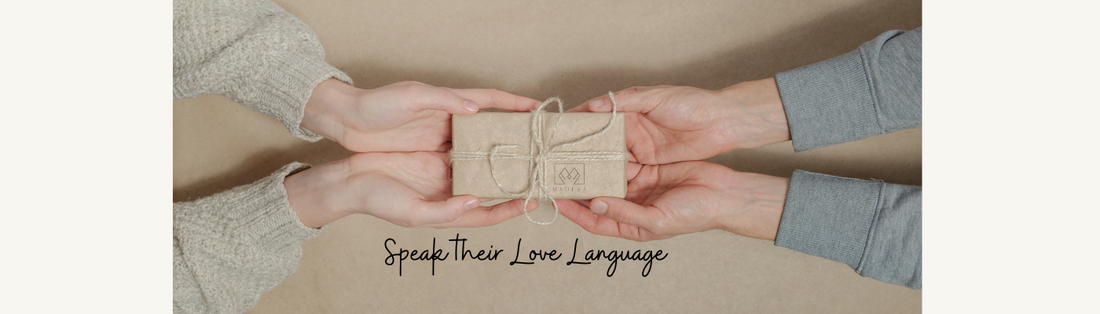 love language of gift giving - two sets of hands holding a small gift of wooden jewelry