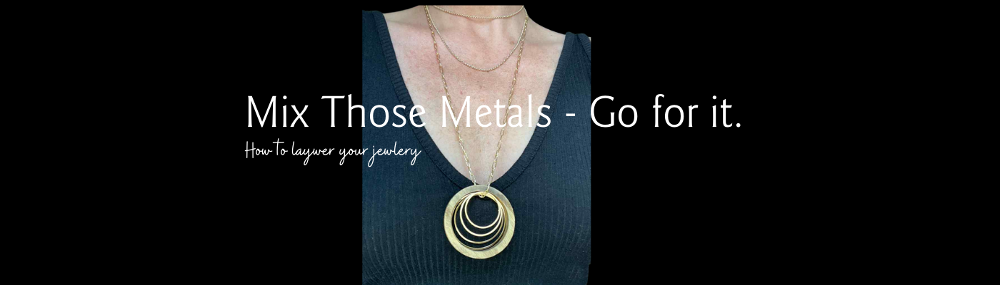 Layering Jewelry - Mix your metals - photo so model with circles necklace and other chains on a black shirt