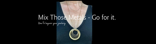 Layering Jewelry - Mix your metals - photo so model with circles necklace and other chains on a black shirt