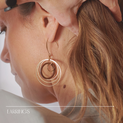 Gold and wood circles earrings on a model's ear close up
