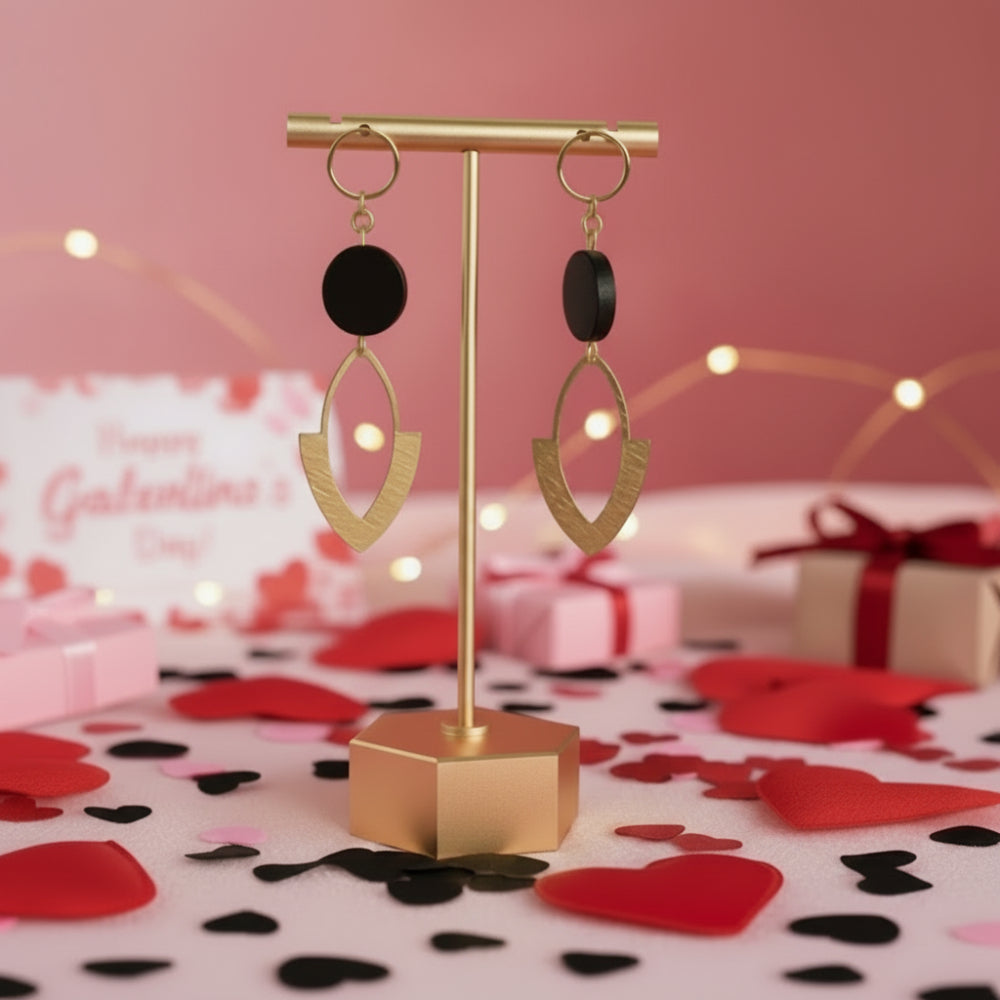 Black bead and brass marquise earrings on a gold stand.
