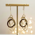 Circles Wooden and Metal Earrings by Mad Era Design Studio on a glittering background