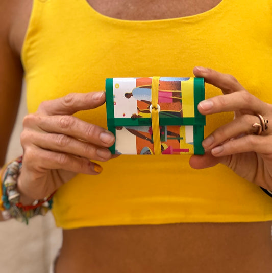 Upcycled carton wallet. green and white, held by model