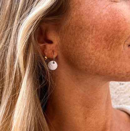 model wearing medium white paper bead hoop earrings