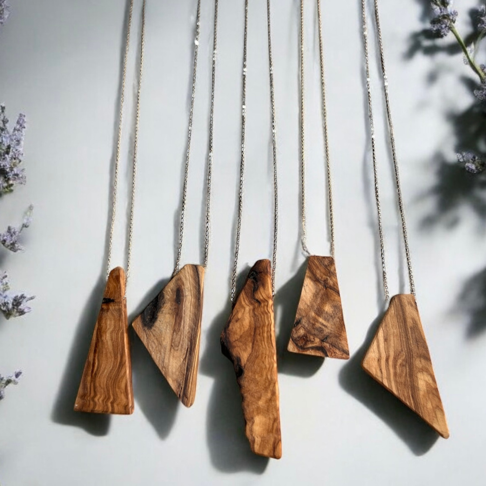 Five wooden pendants on chains against a light background with floral elements.