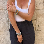 Woman standing on stone wall wearing 6 bracelets - made of recycled paper in Croatia