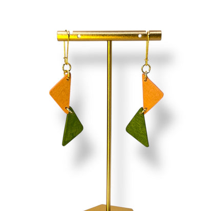two wooden half triangles painted peach and green hang from a gold ear hook. 