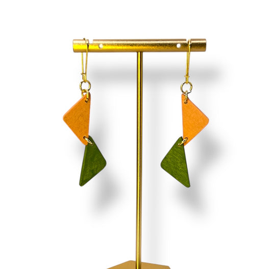 two wooden half triangles painted peach and green hang from a gold ear hook. 