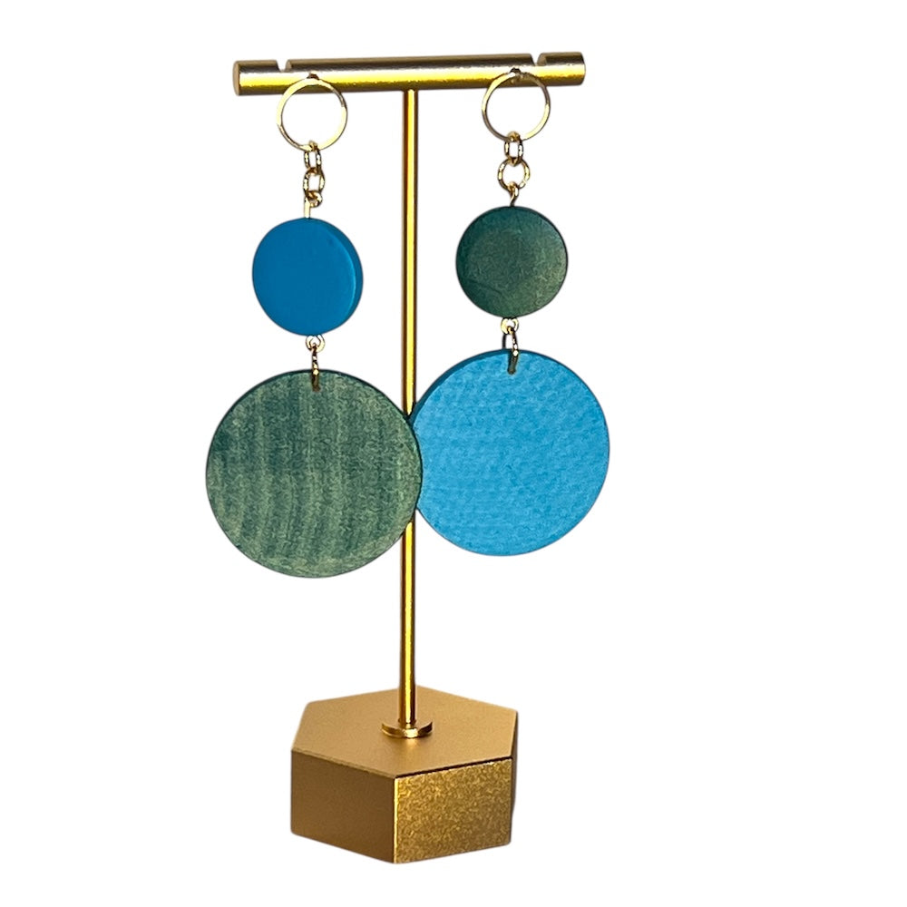 Earrings on a stand, hand painted blue and green circles. 