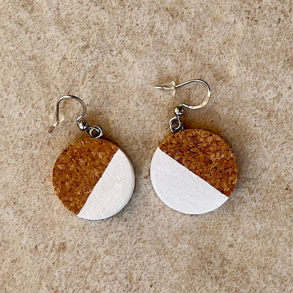 recycled wine bottle cork earrings painted 1/2 white on stone background