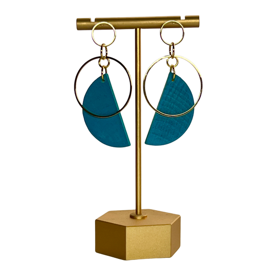 Blue earrings on a gold stand with a white background