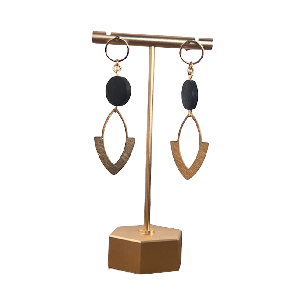 Gold and black earrings on a gold stand with a white background