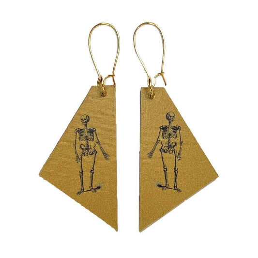 Madera design studio skeleton earrings on mustard yellow background