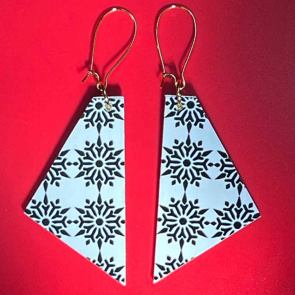 Snowflake earrings on red background by Madera Design Studio