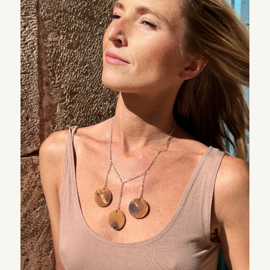 Three olive wood circles hang from a sterling silver plated chain on a woman in Croatia