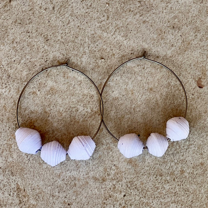 Three recycled white paper beads hand from a large silver hoop.