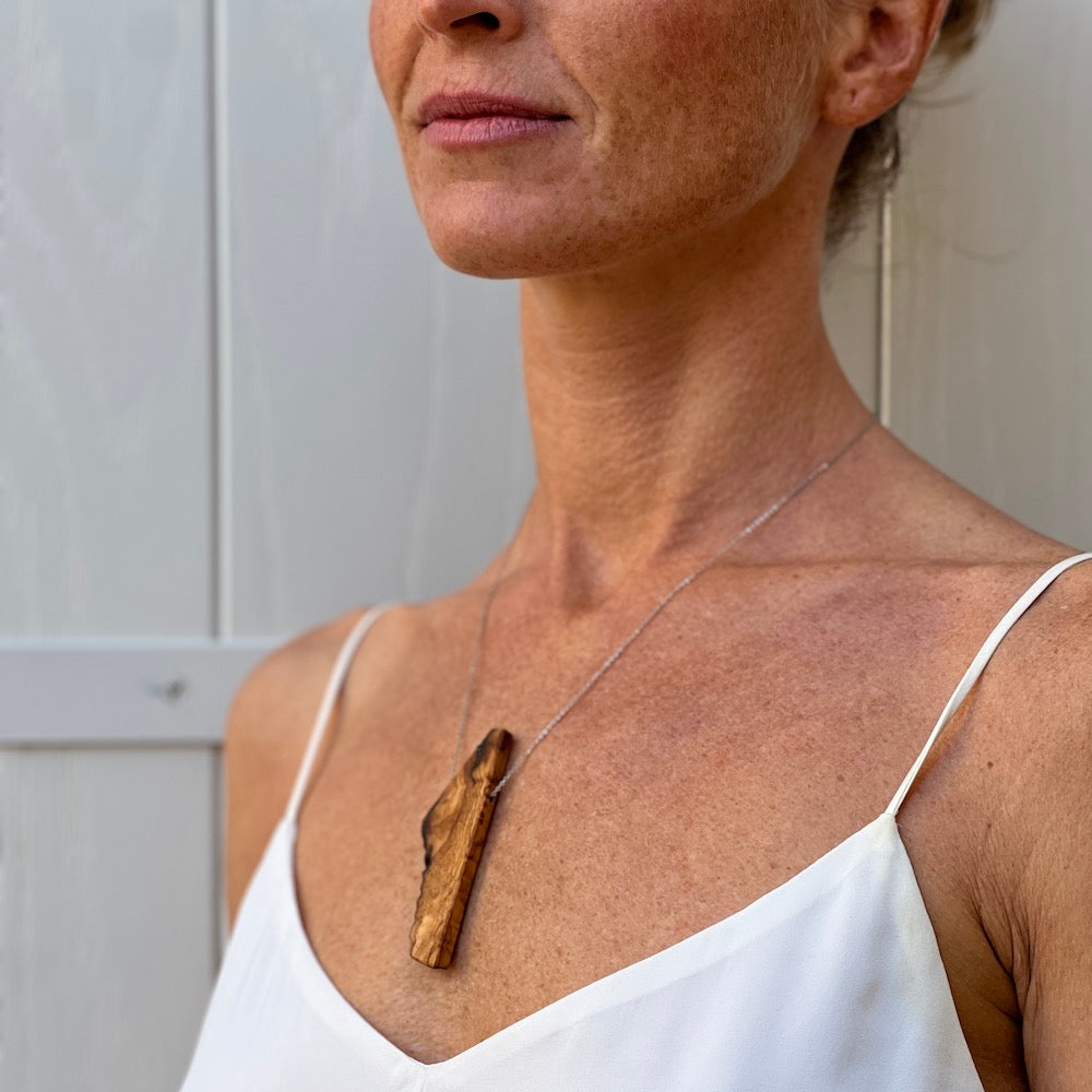 Upcycled olive wood beads handmade by Madera Design Studio on sterling silver chain on model in Croatia. Statement Jewelry